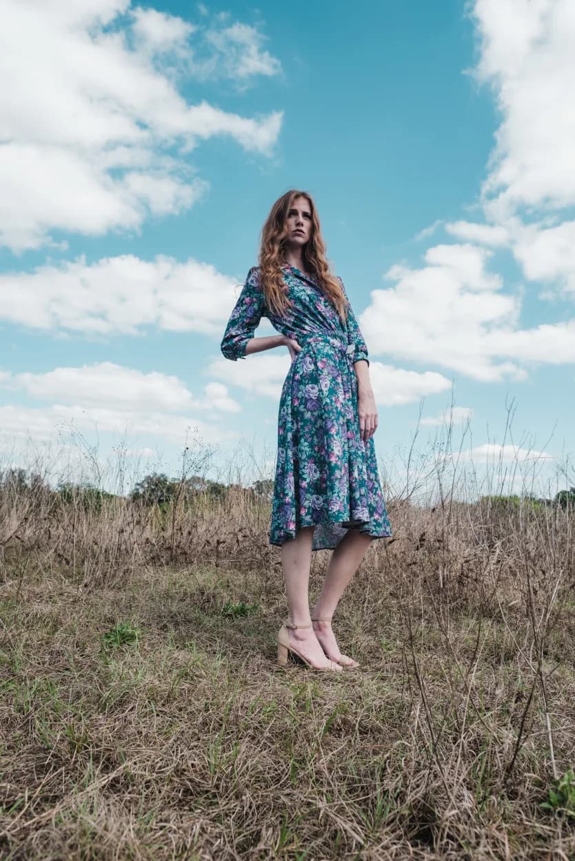 Person wearing a blue dress in an open field
