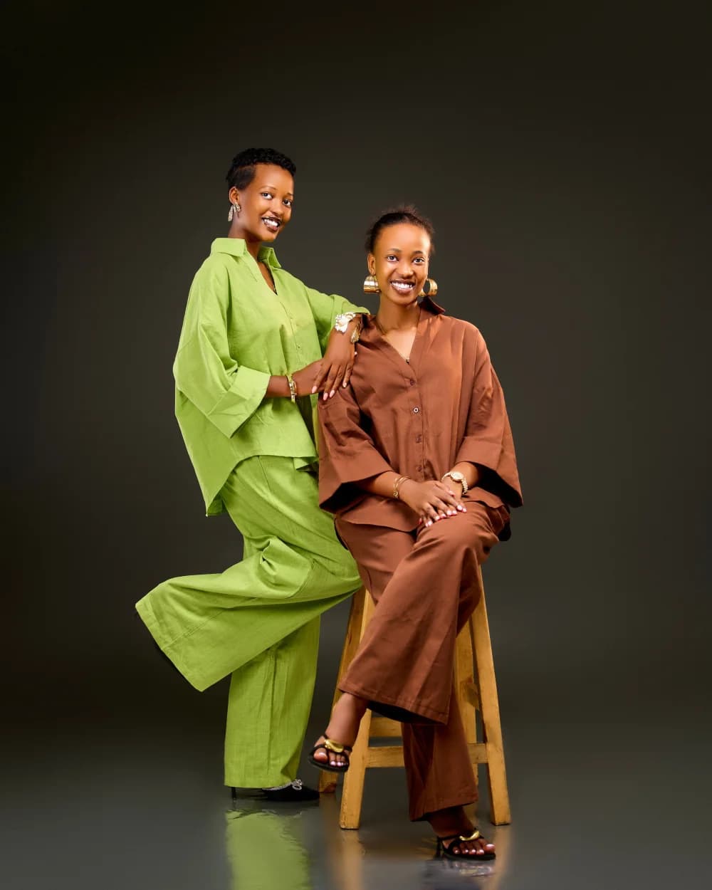Two people in vivid green and brown tailoring