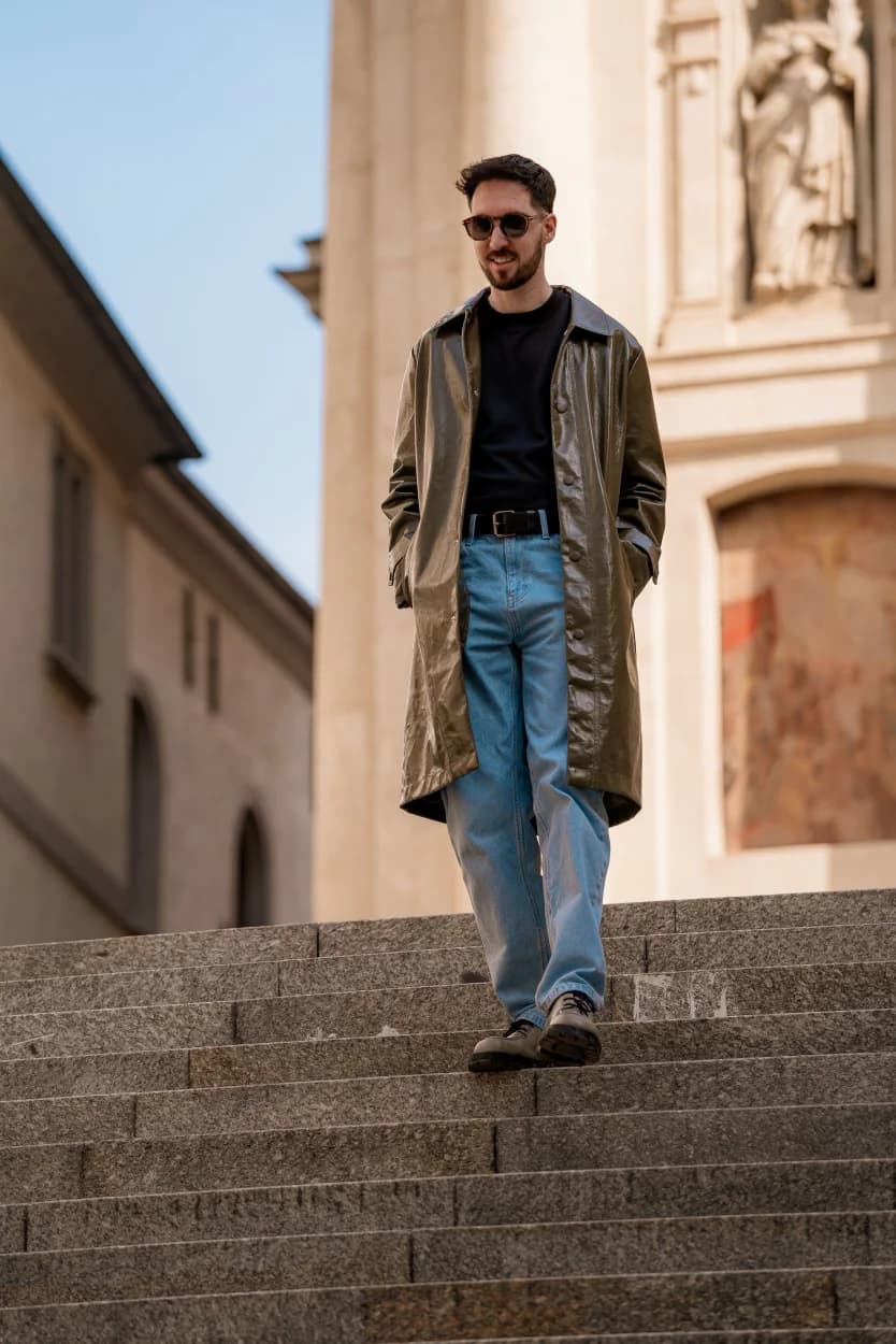 Person wearing a layered city look on stone steps